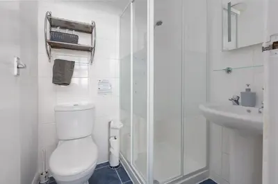 a white bathroom with a toilet and a sink at The Fairmile in Lytham St Annes