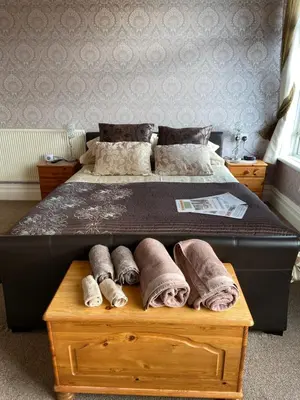 a bed with rolled towels on a wooden box at The Fairmile in Lytham St Annes