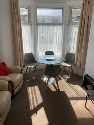a living room with a glass table and two chairs at Delamere holiday flat in Blackpool