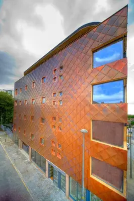 an orange brick building with windows on a street at The Print Works Apartments in Liverpool