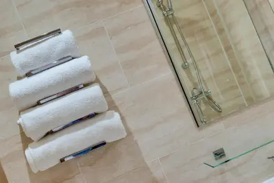 a bathroom with a shower and four towels at The Print Works Apartments in Liverpool