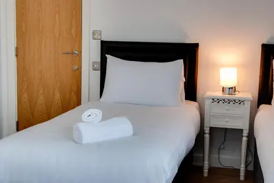 a bedroom with a bed with a white towel on it at The Print Works Apartments in Liverpool