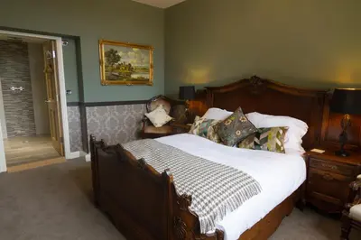 a bedroom with a large bed with a wooden frame at The Red Pump Inn in Clitheroe