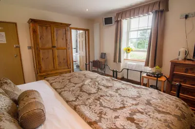 a bedroom with a large bed and a window at The Red Pump Inn in Clitheroe