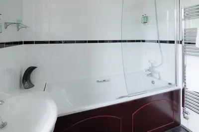 a bathroom with a tub and a glass shower at The Red Pump Inn in Clitheroe