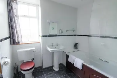 a white bathroom with a toilet and a sink at The Red Pump Inn in Clitheroe