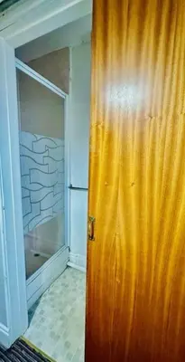a wooden door in a room with a refrigerator at The Avon in Blackpool