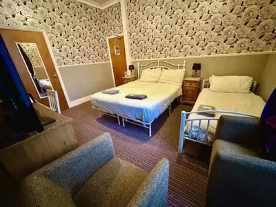 a hotel room with two beds and a couch at The Avon in Blackpool
