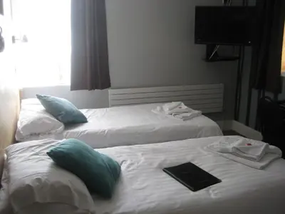 two beds in a hotel room with a tablet on them at The Dragonfly in Blackpool