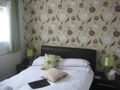a bedroom with a bed with a flowery wallpaper at The Dragonfly in Blackpool