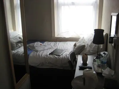 a bedroom with a bed and a desk with a mirror at The Dragonfly in Blackpool