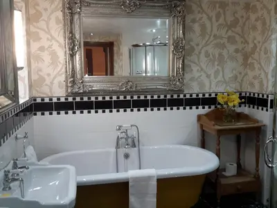 a bathroom with a tub and a mirror and a sink at The Lonsdale in Blackpool