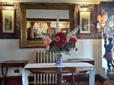 a vase of flowers on a table with a mirror at The Lonsdale in Blackpool