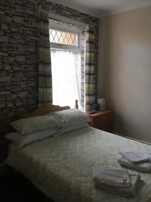 a bedroom with a bed with a brick wall and a window at Royal Hotel in Blackpool