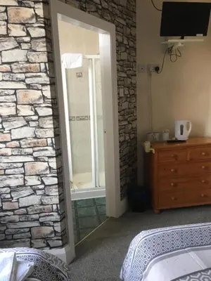 a bedroom with a stone wall and a mirror at Royal Hotel in Blackpool