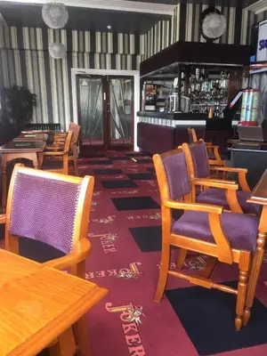 a restaurant with chairs and tables and a bar at Royal Hotel in Blackpool