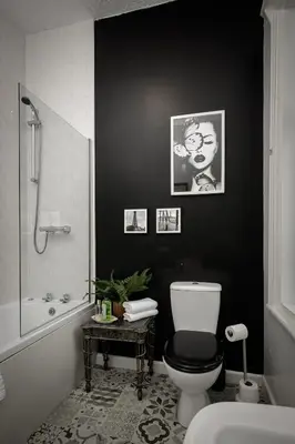 a black bathroom with a toilet and a bath tub at Hornby Apartments in Blackpool