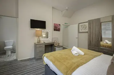 a bedroom with a bed and a desk and a television at Hornby Apartments in Blackpool
