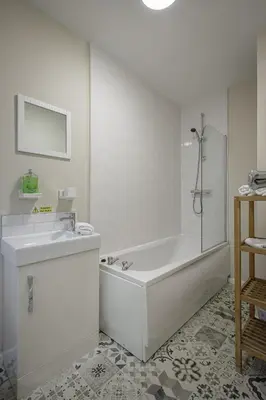 a white bathroom with a tub and a sink at Hornby Apartments in Blackpool