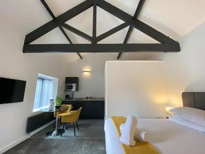 a bedroom with a bed and a dining room with a table at Crows Hotel in Lancaster