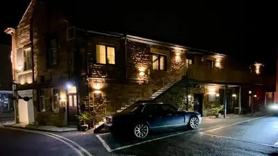 a car parked in front of a building at night at Crows Hotel in Lancaster