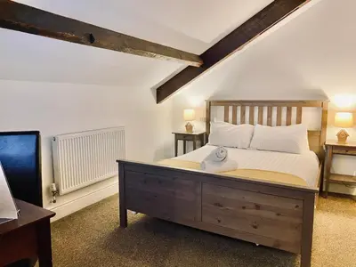 a bedroom with a large bed with a wooden headboard at Crows Hotel in Lancaster