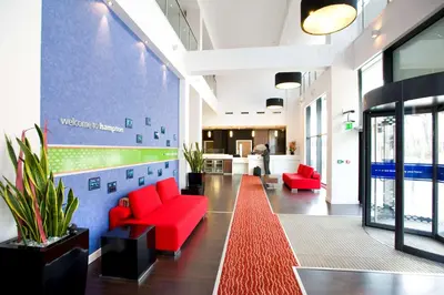 an office lobby with red furniture and a red carpet at Hampton By Hilton Liverpool City Centre in Liverpool