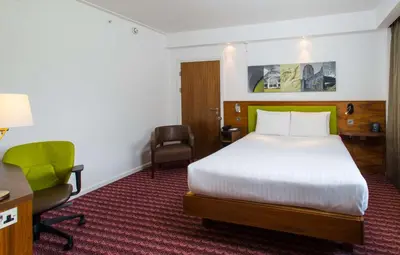a hotel room with a bed and a desk and chair at Hampton By Hilton Liverpool City Centre in Liverpool