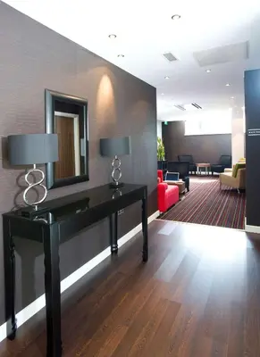 a hotel lobby with a desk and a mirror at Hampton By Hilton Liverpool City Centre in Liverpool