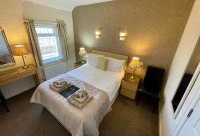 a hotel room with a bed with two towels on it at Windsor Park Hotel in Blackpool