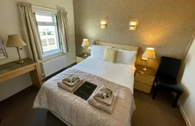 a hotel room with a bed with two towels on it at Windsor Park Hotel in Blackpool