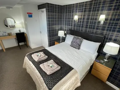 a bedroom with a bed with two towels on it at Windsor Park Hotel in Blackpool