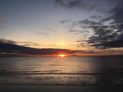 a sunset on the beach with the sun in the distance at Windsor Park Hotel in Blackpool