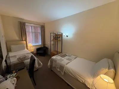 a hotel room with two beds and a window at Windsor Park Hotel in Blackpool