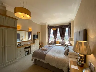 a bedroom with a bed and a desk with a lamp at Bedford Hotel in Lytham St Annes