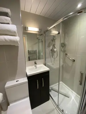a bathroom with a shower and a sink and a glass shower stall at Bedford Hotel in Lytham St Annes