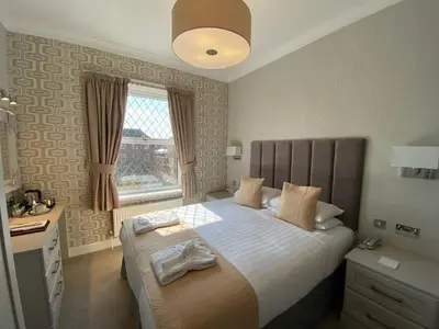 a bedroom with a bed and a desk and a window at Bedford Hotel in Lytham St Annes