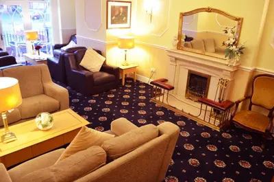 a living room with a couch and a fireplace at Bedford Hotel in Lytham St Annes