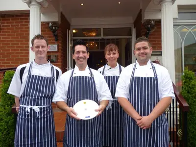 a group of four men in aprons holding a plate at Bedford Hotel in Lytham St Annes