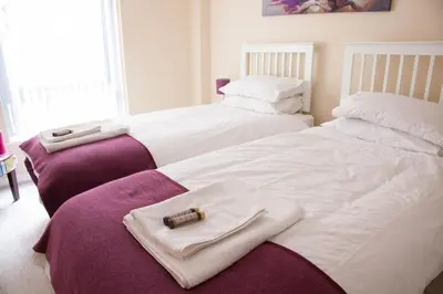 two beds with towels and a bible on top of them at City Centre Luxury Holiday Apartment in Liverpool