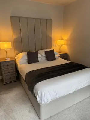 a bedroom with a large white bed with two lamps at Beach House Apartment on ground floor with sea view - pet friendly in Cleveleys