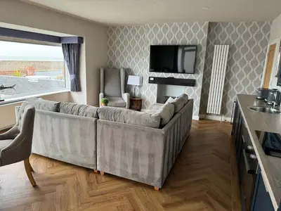 a living room with a couch and a television at Beach House Apartment on ground floor with sea view - pet friendly in Cleveleys