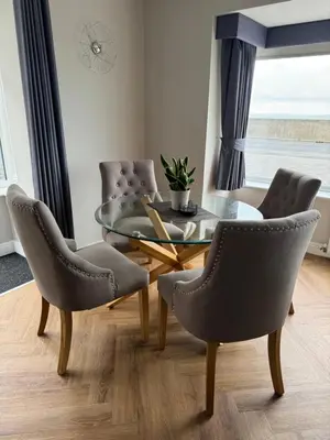 a dining room with a glass table and chairs at Beach House Apartment on ground floor with sea view - pet friendly in Cleveleys