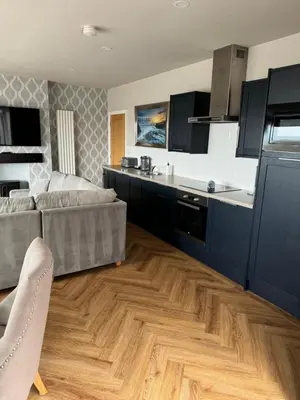 a living room with a couch and a kitchen at Beach House Apartment on ground floor with sea view - pet friendly in Cleveleys