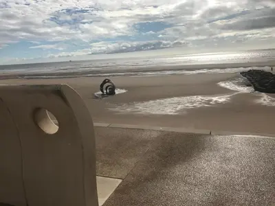 a person laying in the sand on the beach at Beach House Apartment on ground floor with sea view - pet friendly in Cleveleys