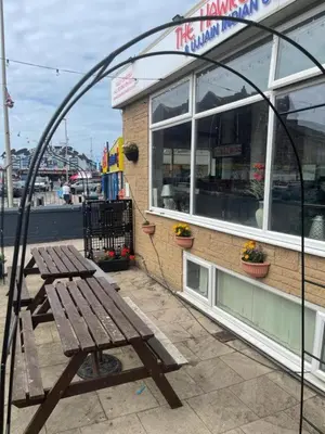 a wooden picnic table sitting outside of a restaurant at Dora Hotel in Blackpool