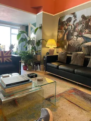 a living room with a black couch and a painting at ParkRoyal Blackpool in Blackpool