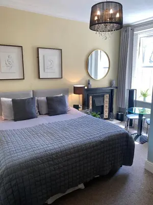 a bedroom with a bed and a fireplace and a mirror at ParkRoyal Blackpool in Blackpool