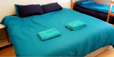 a blue bed with two pillows on top of it at The Osprey Hotel in Blackpool