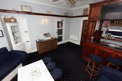 a room with a bar with chairs and a table at The Osprey Hotel in Blackpool